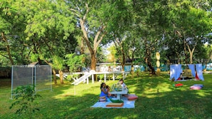 An outdoor setting with a picnic table, a fenced area, and trees. - Saffron Garden Malindi (Mombasa)