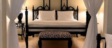 A bedroom with a bed, a bench, and a table.