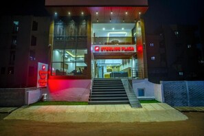 A building with a prominent 'Sterling Plaza' sign, a staircase leading to an entrance, and a well-lit facade. - The Hoften Sterling Plaza Near BLR Airport (Bengaluru)