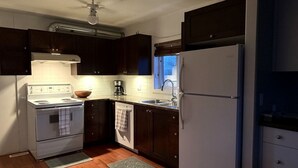 A compact kitchen with a stove, sink, and refrigerator, wooden cabinets, and a window. - Veregin Getaway- Snowmobile trails, Fishing, Hunting, Golf, Lakes, Relaxing (Veregin)