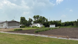 A residential area with houses, a grassy lawn, and a clear sky. - Veregin Getaway- Snowmobile trails, Fishing, Hunting, Golf, Lakes, Relaxing (Veregin)