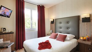 A hotel room with a bed, a desk, a television, and a window with curtains. - Pont Du Chalon Hôtel And Restaurant (Marges)