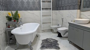 A bathroom with a freestanding bathtub, a bidet, a toilet, and a vanity with a sink. - Isa Begov Hamam Hotel (Sarajevo)