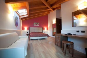 A bedroom with a bed, a desk, a chair, a mirror, and a skylight. - Hotel Eridano (Sannazzaro de Burgondi)