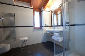 Une salle de bain moderne avec une douche à parois de verre, un lavabo blanc et des toilettes.