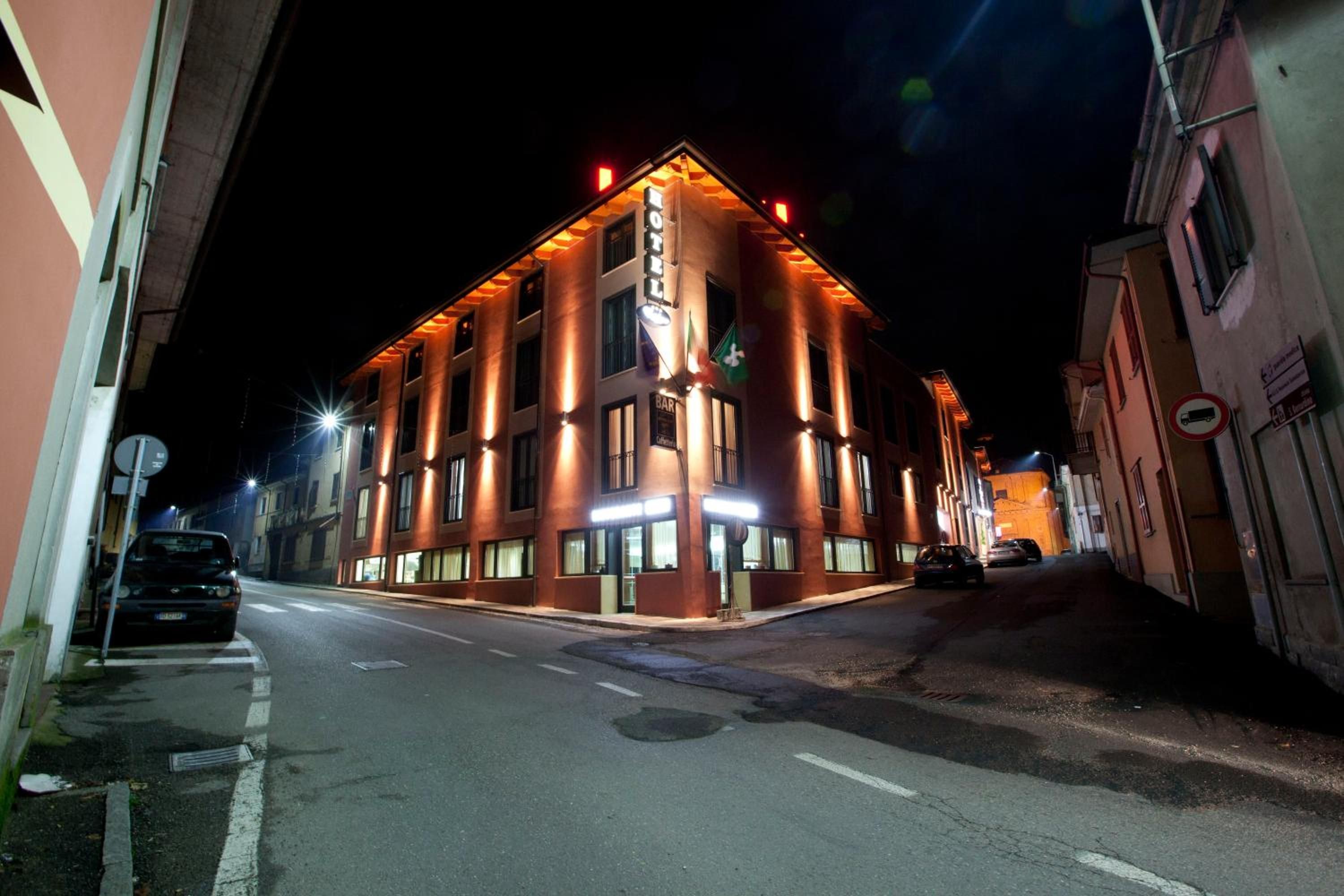 A hotel with a corner location, multiple floors, and illuminated signage.