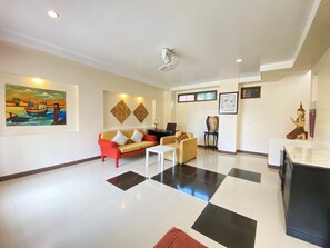 A modern living room with a sofa, coffee table, and artwork on the walls. - Kohhai Fantasy Resort&spa (Krabi)