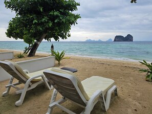 A beachside setting with two white lounge chairs and a tree providing shade. - Kohhai Fantasy Resort&spa (Krabi)
