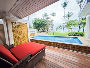 A poolside area with a lounge chair, a view of a pool, and a beach with palm trees. - Kohhai Fantasy Resort&spa (Krabi)