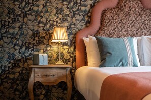 A bed with pillows, a bedside lamp, and a nightstand with a box. - The Bear (Bath)