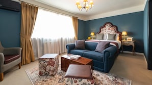 A hotel room with a bed, a sofa, a coffee table, a chair, and a window with curtains. - The Bear (Bath)