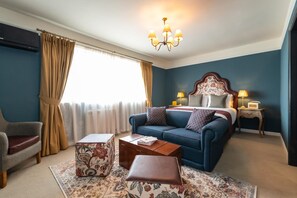 A hotel room with a bed, a sofa, a coffee table, a chair, and a window with curtains. - The Bear (Bath)