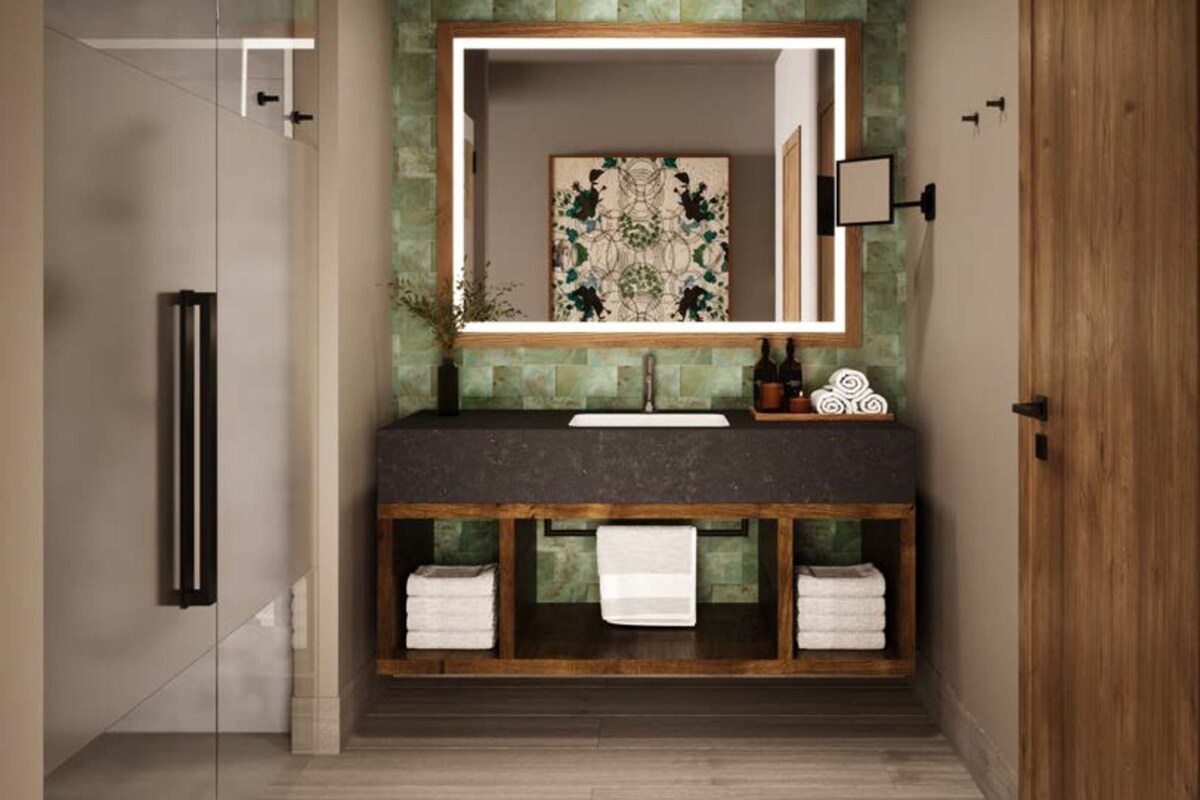 A modern bathroom with a stone backsplash, a wooden vanity, a large mirror, and a glass shower enclosure.