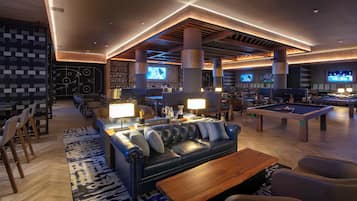A modern lounge area with a pool table, comfortable seating, and a bar area with multiple screens.