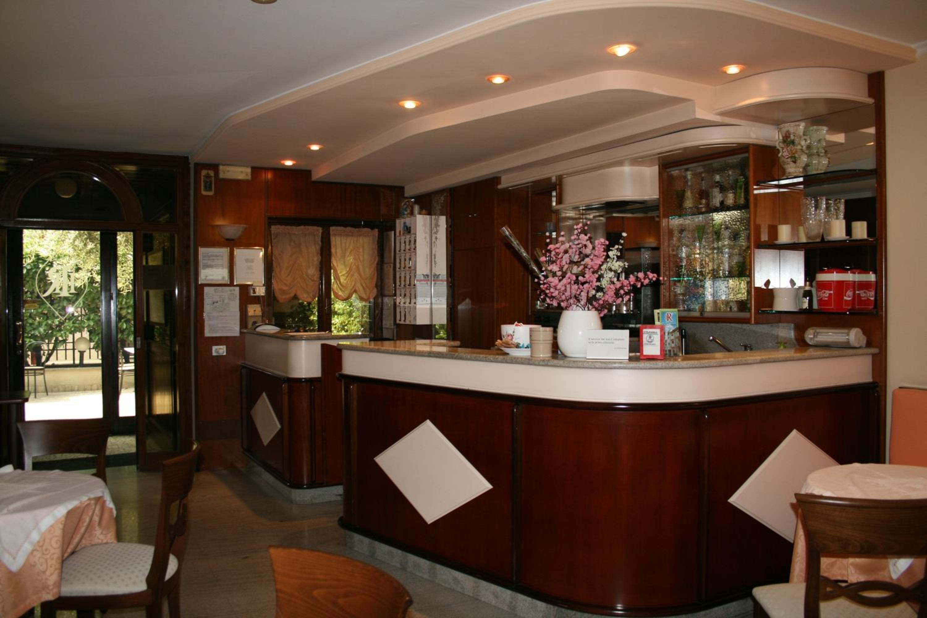 Un'hall d'albergo con reception, area relax e vista sull'esterno.