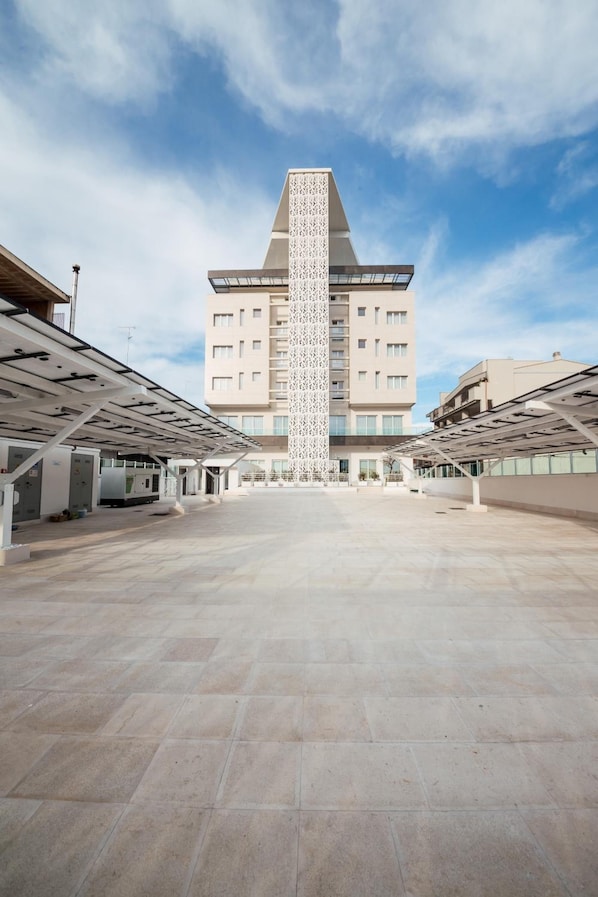 A modern building with a central tower, multiple floors, and a spacious courtyard. - Grieco Business & Spa Hotel (Cerignola)