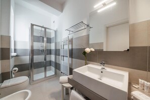 A modern bathroom with a glass shower enclosure, a white sink, and a mirror above the vanity. - Grieco Business & Spa Hotel (Cerignola)