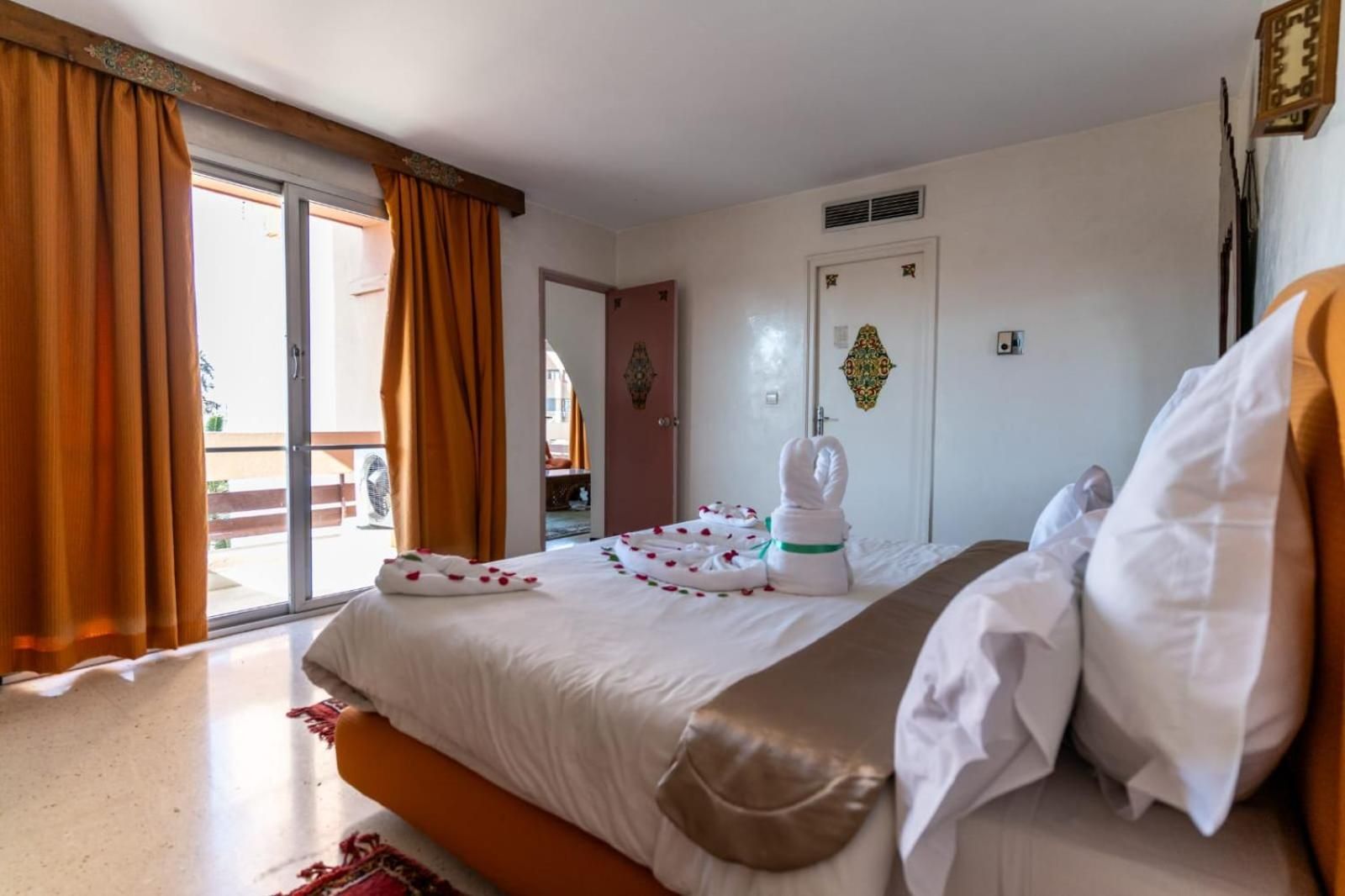 Une chambre d’hôtel avec un lit, une porte de salle de bain et une vue sur l’extérieur.