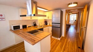 A compact kitchen with a microwave, toaster, sink, and stainless steel refrigerator. - Villa Viktoria 1 - Apartments - City Center (Ingolstadt)