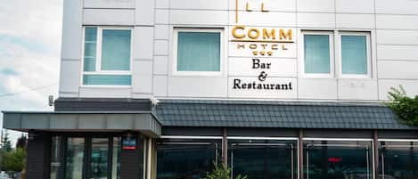 A hotel with a prominent sign indicating it has a bar and restaurant.