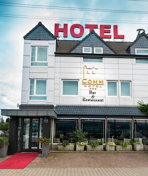A hotel with a prominent sign indicating it has a bar and restaurant. - Comm Hotel Poznan Airport (Poznań)