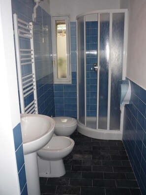 A bathroom with two toilets, a shower enclosure, and a towel rack. - Affittacamere Andronaco (Milan)