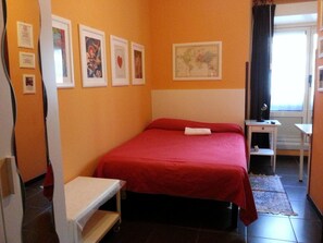 A hotel room with a bed, a desk, a chair, and a window with curtains. - Affittacamere Andronaco (Milan)