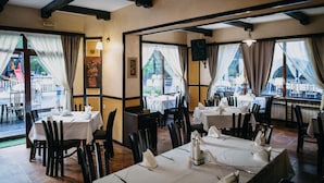 Een restaurant met gedekte tafels, een uitzicht op het buitengebeuren en een bord dat een uitgang aangeeft.