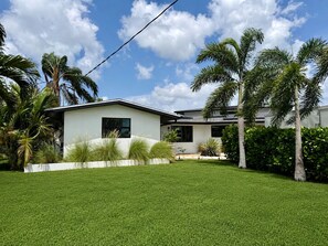 A modern two-story house with a well-maintained lawn and tropical landscaping. - Sarasota Private Gateway Paradise (Sarasota)