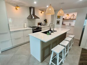 A modern kitchen with a central island, stainless steel appliances, and pendant lighting. - Sarasota Private Getaway Paradise (Sarasota)