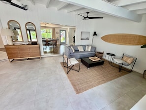 A spacious living room with a sofa, coffee table, and side chairs. There is a dining area with a table and chairs visible through an open doorway. - Sarasota Private Getaway Paradise (Sarasota)