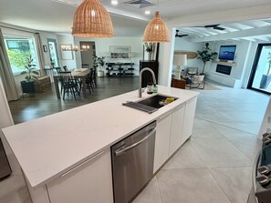 A modern kitchen with a central island, stainless steel appliances, and pendant lighting. - Sarasota Private Getaway Paradise (Sarasota)