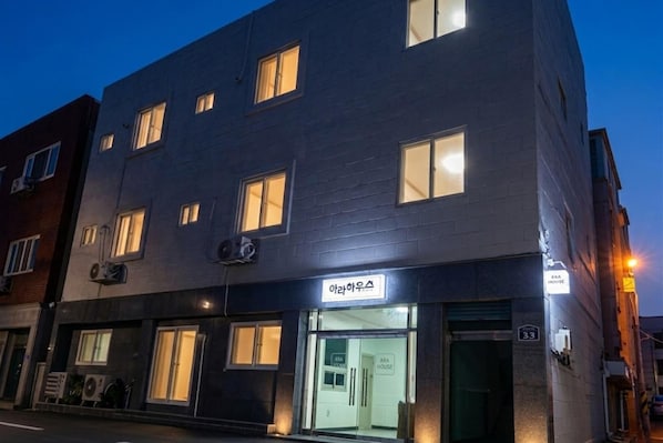 Un edificio de varios pisos con un letrero que indica 'ARA HOUSE' y el número '33' en la fachada.
