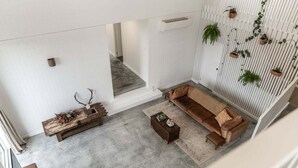 A modern living room with a sofa, coffee table, and decorative items. - White Pebble - Bicheno Accommodation (Bicheno)