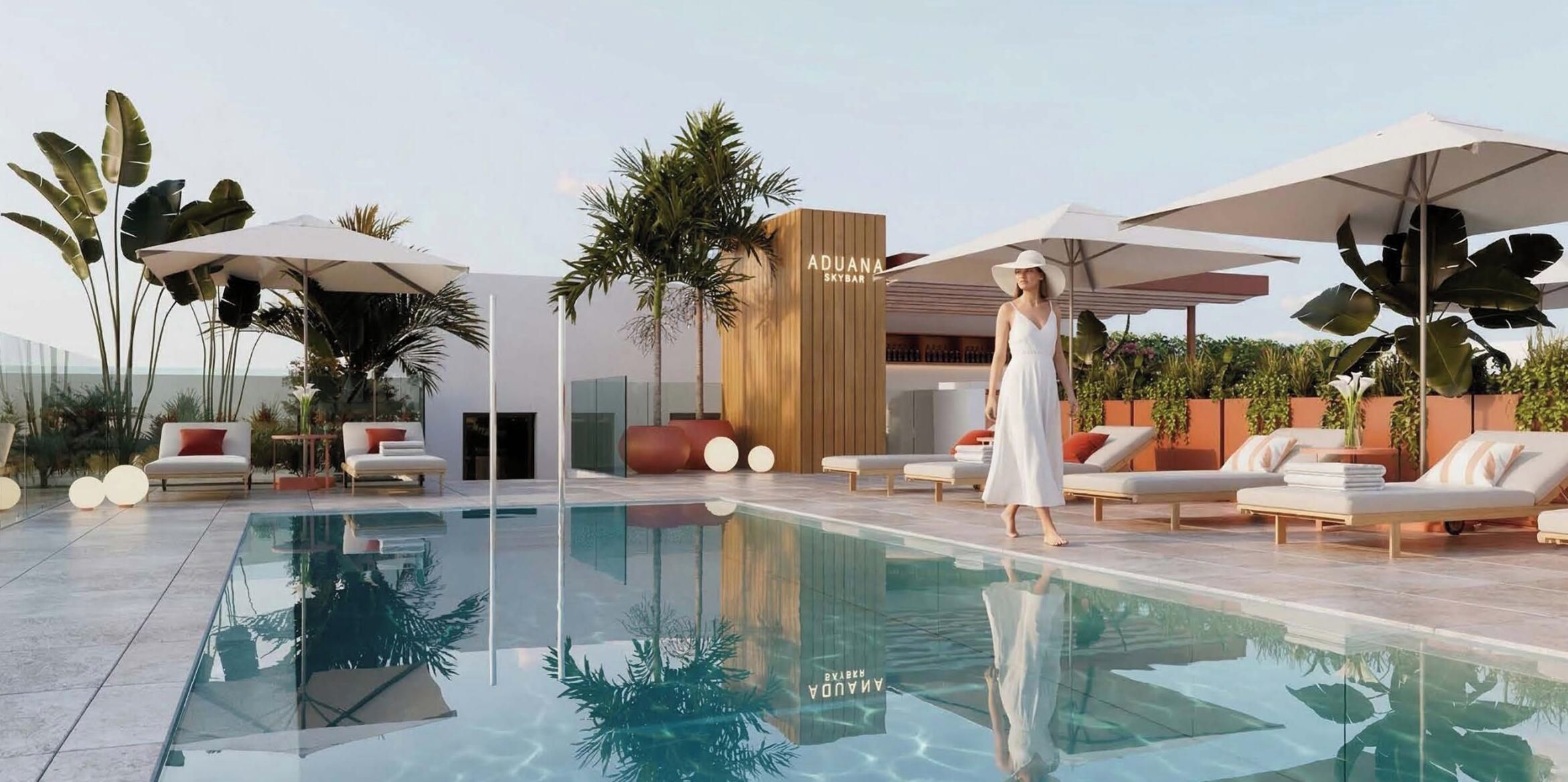 A modern pool area with lounge chairs, umbrellas, and a bar area.