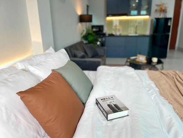 Una cama bien hecha con un libro titulado 'Kelly Wearstler'.