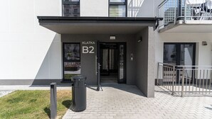 Ein moderner Gebäudeeingang mit einem Schild, auf dem 'KLATKA B2' steht.