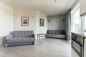 En moderne stue med to grå sofaer, et lille sofabord og billedkunst på væggene.