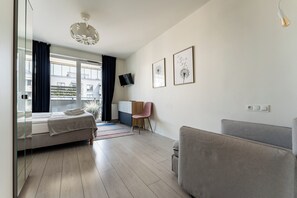 Ein modernes Schlafzimmer mit einem Bett, einem Schreibtisch, einem Sessel und einer Couch.
