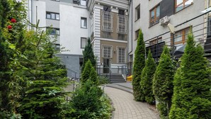 A pathway leading to a building with a staircase, surrounded by greenery and potted plants. - Targ Rybny Riverside Apartment (Szczecin)