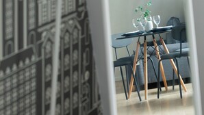 A dining area with a table set for two, a chair, and a decorative plant. - Targ Rybny Riverside Apartment (Szczecin)