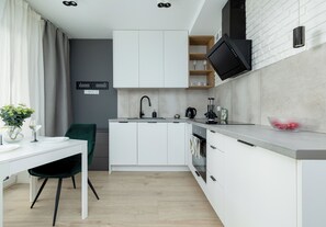 Eine moderne Küche mit weißen Schränken, einem schwarzen Wasserhahn und einem eingebauten Backofen.