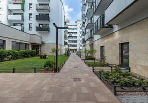 A multi-story residential building with balconies, a paved walkway, and greenery. - Szczecin Bronowicka Malachite Studio (Szczecin)