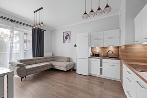 Eine moderne Küche mit weißen Schränken, einer Holz Arbeitsplatte und einem eingebauten Backofen.