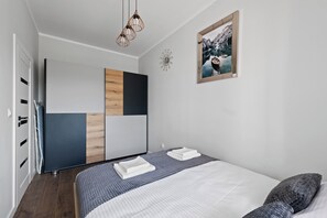 Ein modernes Schlafzimmer mit einem Bett, einem Nachttisch, einer Wanduhr und einem gerahmten Bild.