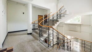 A spacious interior with a grand staircase, white walls, and a high ceiling. - Nowy Świat Central Apartment (Warszawa)