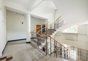 A spacious interior with a grand staircase, white walls, and a high ceiling. - Nowy Świat Central Apartment (Warszawa)
