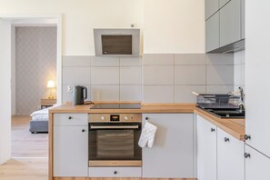 Een kleine keuken met een inbouwoven, een magnetron en een spoelbak.