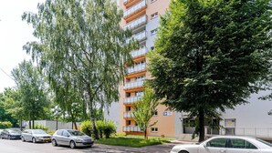 A residential building with multiple floors, balconies, and a parking area with cars. - Morawa Pond Comfort Studio (Katowice)
