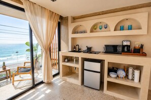 A kitchen with a view of the ocean, a refrigerator, a microwave, and a coffee maker. - Water-front Luxury + King Bed w/AC (Tijuana)